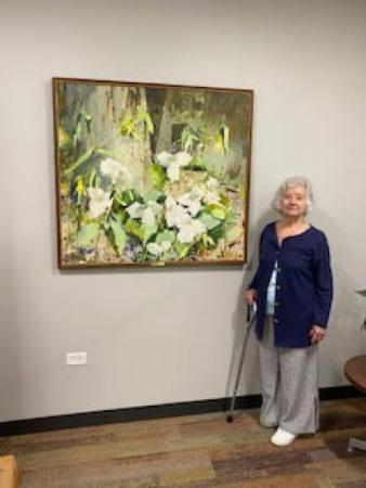 Milvi Wheeler standing next to her painting