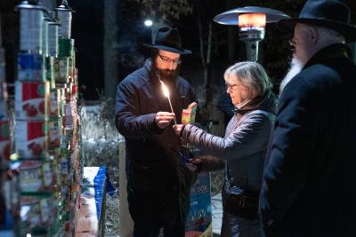 Mayor Ford lighting the Menorah with help from Rabbi Sholom Notik while Rabbi Shmuel Notik looks on