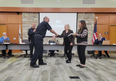 Police Sergeant William Kirby, Mayor Kristine Ford and Deputy Village Clerk Vivian Hofeld congratulate Officer Andrew Kolek.
